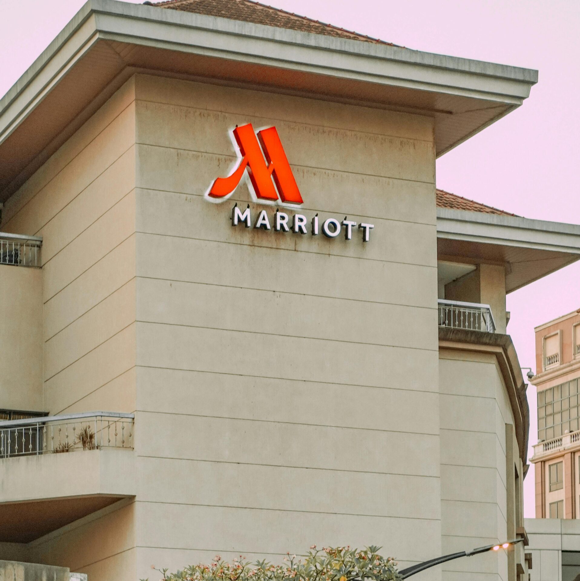 Exterior view of Marriott Hotel building with prominent logo in urban setting.